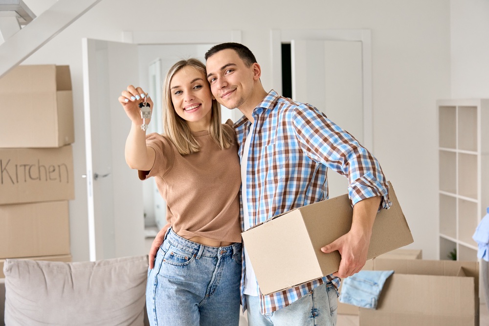happy young couple first time home owners holding their keys