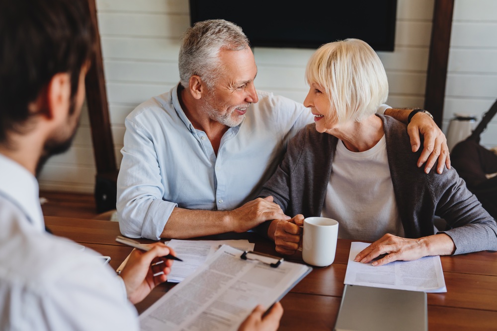 Older couple asking questions to their realtor over coffee
